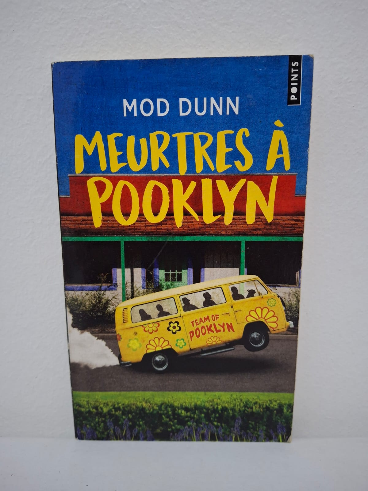 Meurtres à Pooklyn-Mod Dunn Dans la petite ville de Pooklyn, les membres d'une équipe de détectives autrefois célèbres se retrouvent des années plus tard, hantés par leurs échecs et leurs névroses. Loin de l'innocence de leur jeunesse, ils sont replongés dans une affaire de meurtres en série particulièrement violents qui semble liée à leur passé commun. L'auteur détourne les codes du dessin animé pour livrer une satire grinçante, où les monstres ne sont plus des hommes masqués mais les démons intérieurs des protagonistes. Entre humour corrosif et enquête policière nerveuse, le récit déconstruit le mythe du héros pour révéler une réalité beaucoup plus sombre et désenchantée.